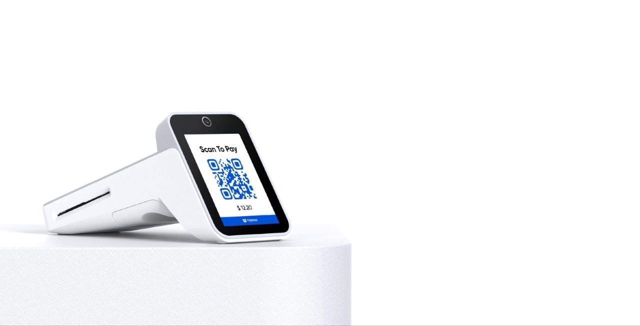 Terminal de comptoir blanc affichant un QR code « Scan To Pay » et un montant